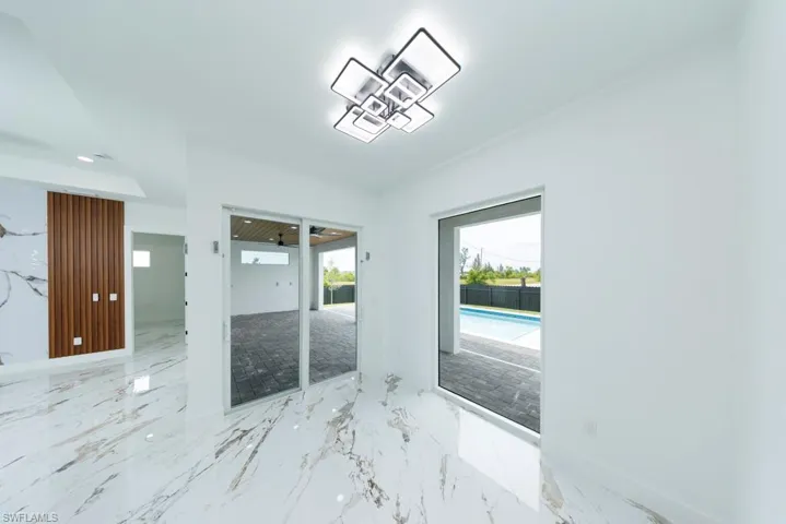 Unfurnished room with marble tiled floors and recessed lighting