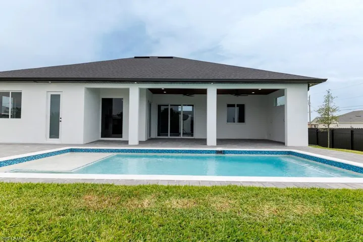 Back of house featuring a patio area, a ceiling fan, stucco siding, and a shingled roof