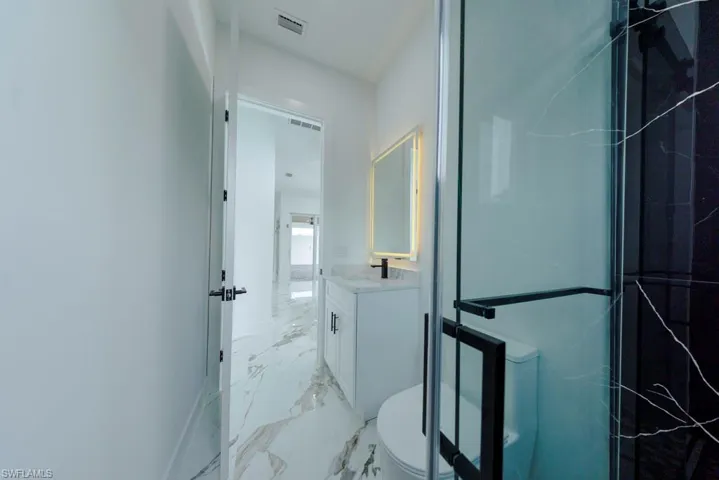 Bathroom with vanity and light marble finish flooring