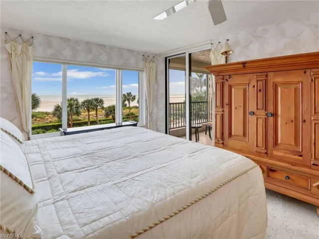 Bedroom with a textured ceiling, ceiling fan, and access to outside