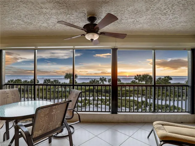 Sunroom featuring a water view and ceiling fan