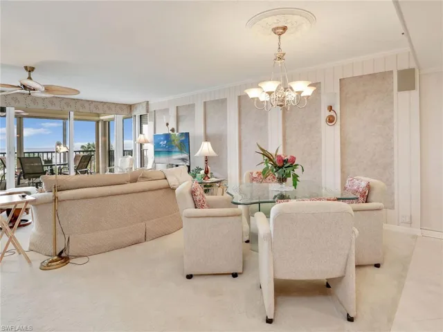 Dining space featuring crown molding and ceiling fan with notable chandelier
