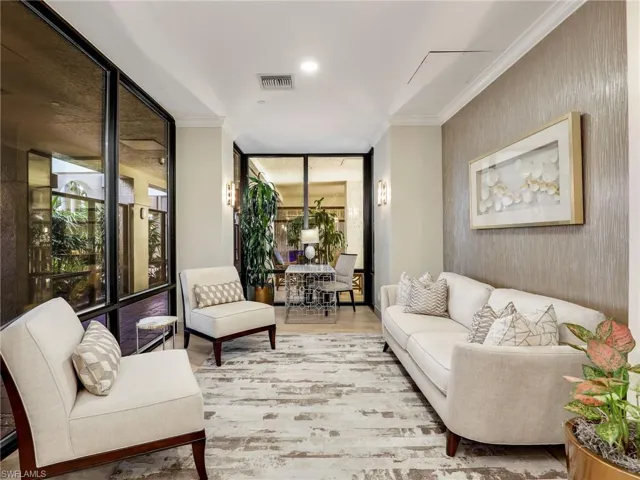 Living room with ornamental molding, floor to ceiling windows, and hardwood / wood-style floors