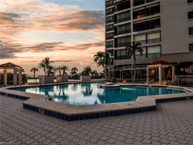 Pool at dusk with a gazebo and a patio area