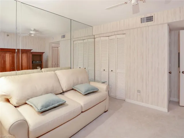 Carpeted living room with ceiling fan