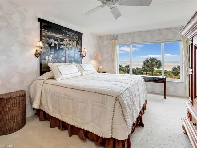 Bedroom with a textured ceiling, ceiling fan, and light carpet