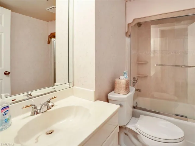 Full bathroom featuring toilet, bath / shower combo with glass door, and vanity