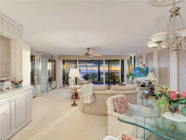 Carpeted living room featuring ceiling fan