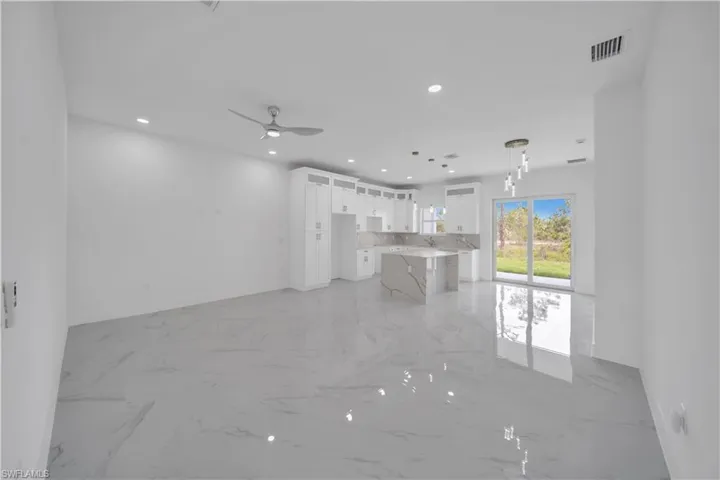 Unfurnished living room featuring light marble finish floors, recessed lighting, and a ceiling fan
