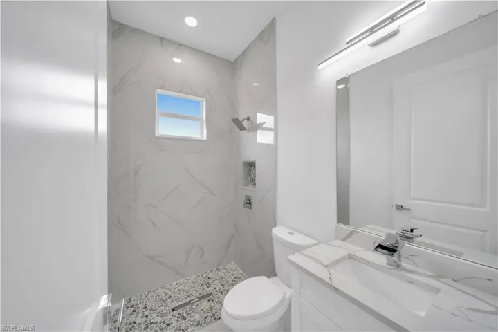 Full bathroom featuring vanity and a marble finish shower