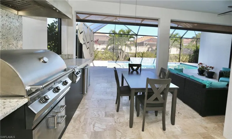 View of patio / terrace featuring an outdoor pool, a lanai, a sunroom, a grill, and an outdoor living / dining area