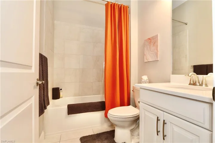 Full bath with vanity, light tile patterned flooring, and shower / tub combo with curtain