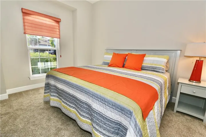 Bedroom featuring light colored carpet and baseboards