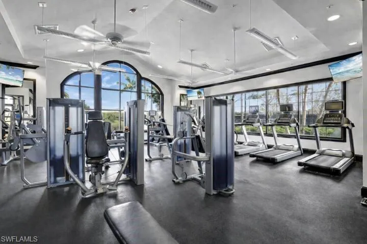 Exercise room with recessed lighting, a tray ceiling, ceiling fan, and ornamental molding