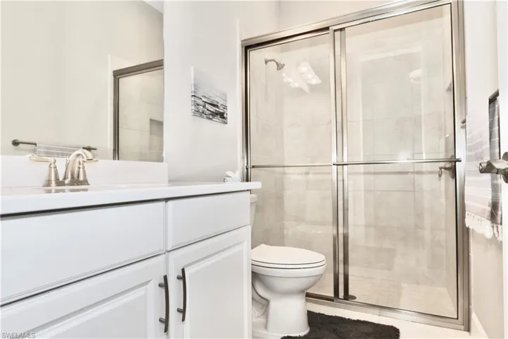 Full bathroom with vanity and a shower stall