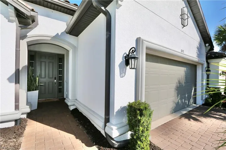 View of side of property featuring stucco siding, driveway, and a garage