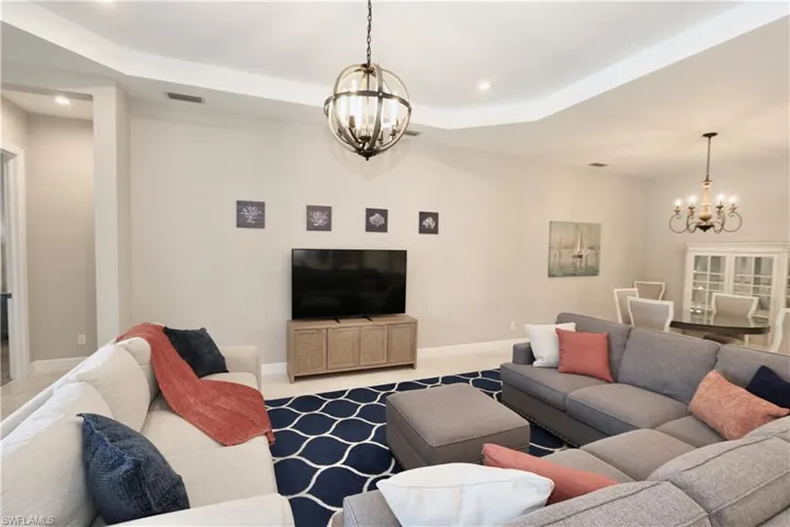 Living area featuring hanging lights, a tray ceiling, and tile patterned floors