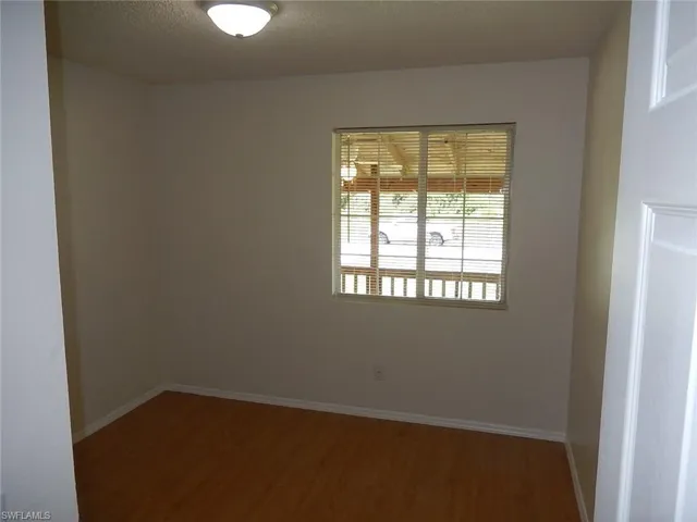 Empty room with wood finished floors and a textured ceiling