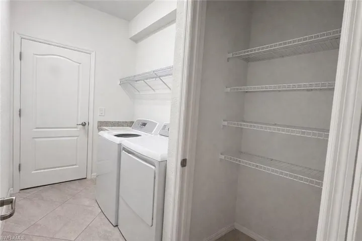 Laundry room featuring independent washer and dryer and light tile patterned floors