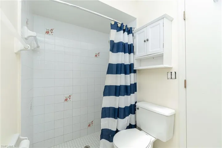 Full bathroom featuring toilet and a shower stall