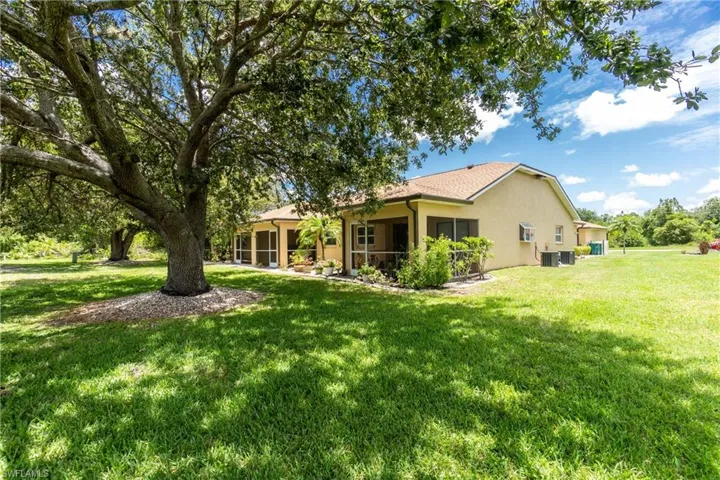 Back of property with stucco siding, a yard, and a sunroom