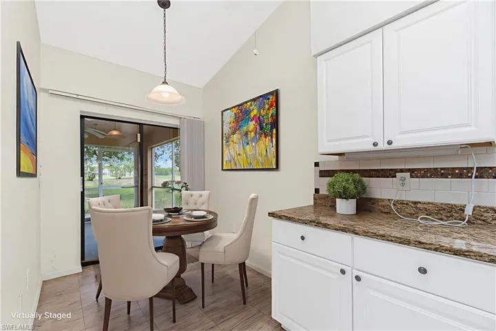 Dining space featuring baseboards and vaulted ceiling