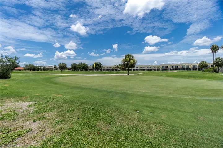 View of property's community with golf course view and a yard