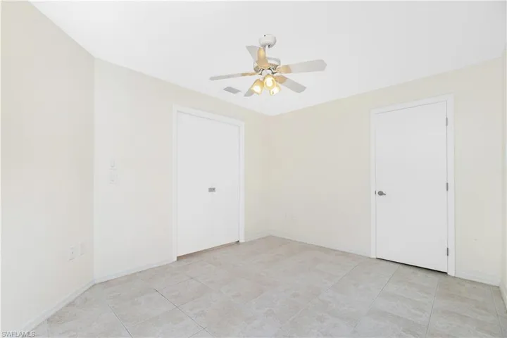 Unfurnished bedroom featuring a ceiling fan and baseboards