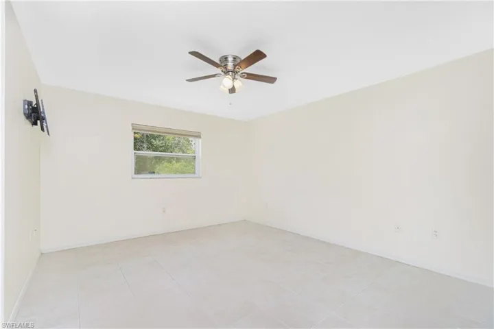 Empty room featuring ceiling fan and baseboards