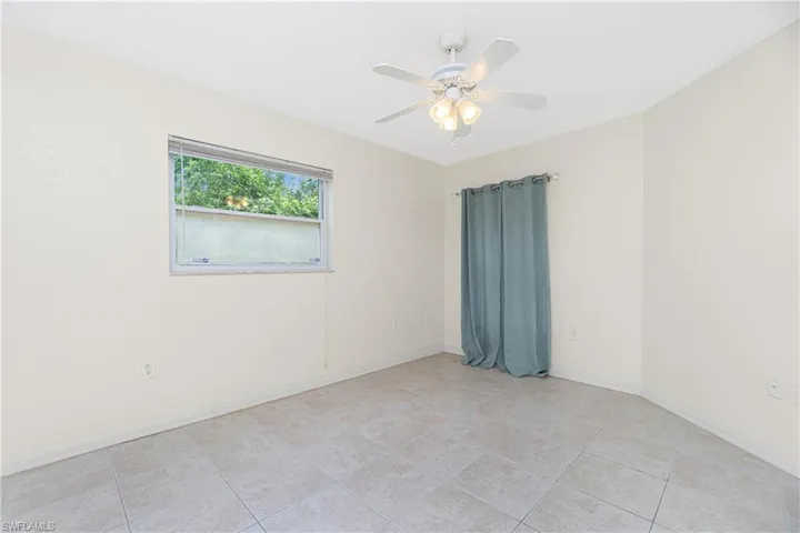 Unfurnished room with ceiling fan and light tile patterned flooring