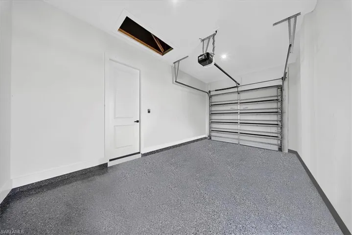 Garage with baseboards and a garage door opener