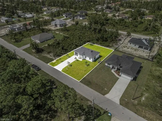 Aerial perspective of suburban area with property parcel outlined and a tree filled landscape