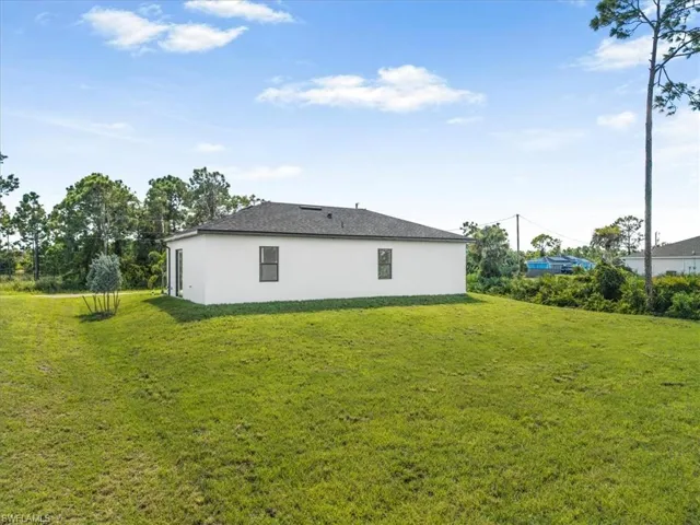 View of property exterior featuring a yard and stucco siding