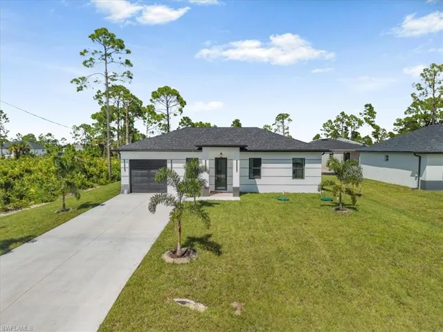 Ranch-style house with a front yard, driveway, and a garage