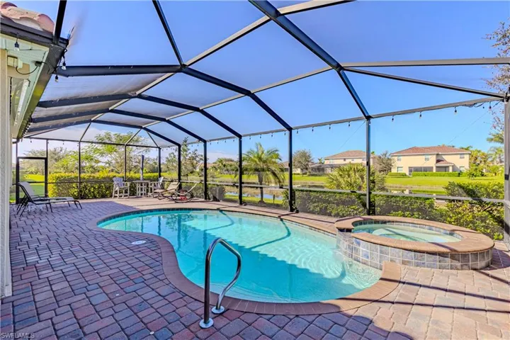 View of pool featuring an in ground hot tub, glass enclosure, and a patio