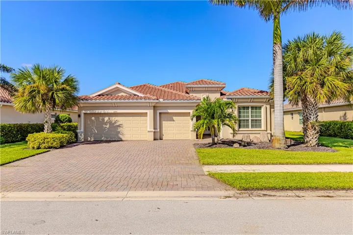 Mediterranean / spanish-style house with a garage and a front lawn