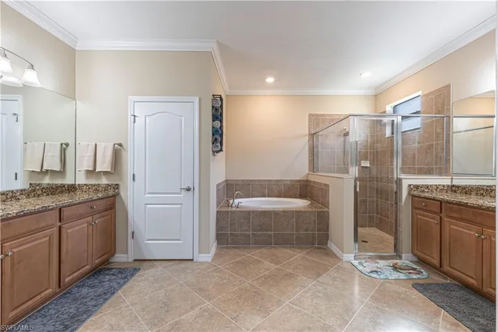 Bathroom with vanity, crown molding, separate shower and tub, and tile patterned floors