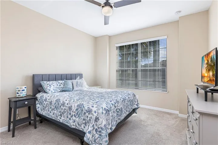 Bedroom with light colored carpet and ceiling fan