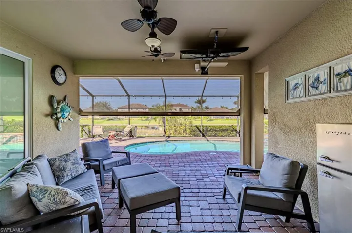 View of patio featuring ceiling fan, an outdoor living space, and a lanai
