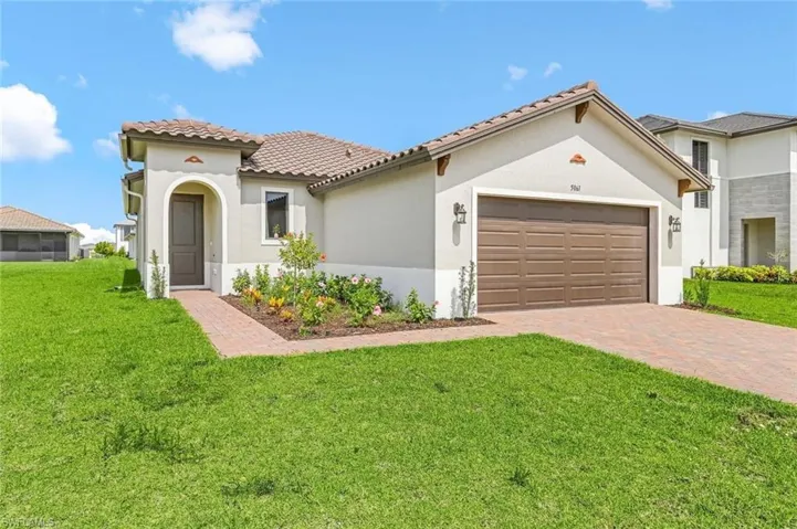 Mediterranean / spanish-style house featuring a front lawn, an attached garage, and stucco siding