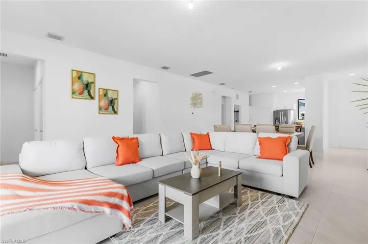 Living area with light tile patterned floors and recessed lighting