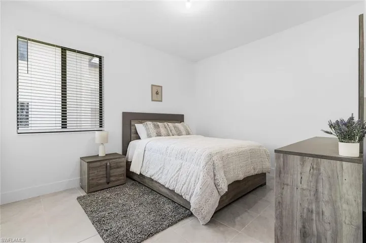 Bedroom with light tile patterned flooring and baseboards
