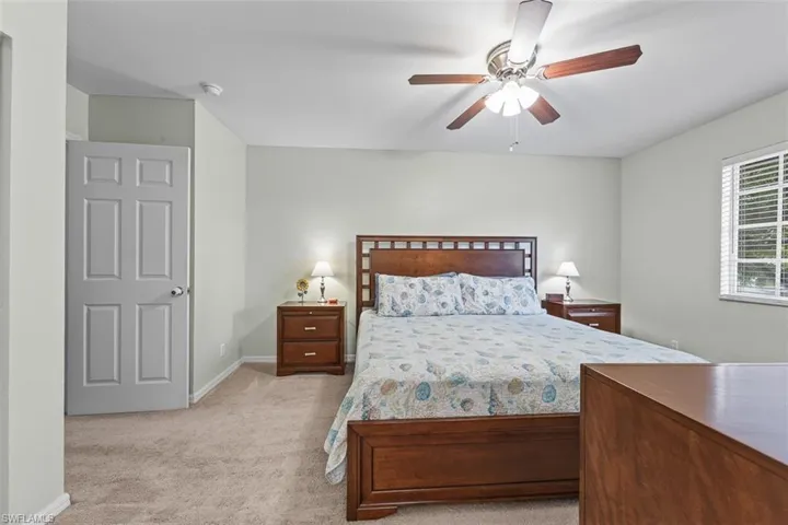 Bedroom with light colored carpet and ceiling fan
