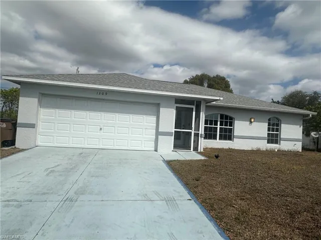 Single story home with a garage, stucco siding, and driveway
