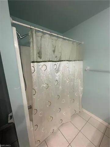 Full bathroom with vanity and light tile patterned floors