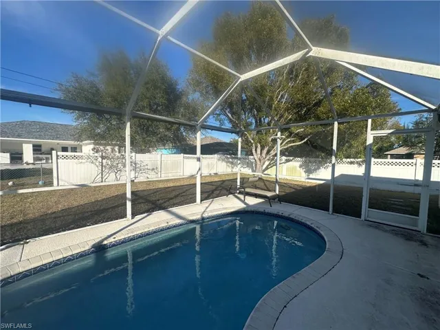 Ranch-style home featuring an attached garage, a front yard, driveway, stucco siding, and roof with shingles