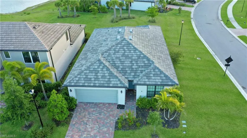 Modern single-story residence featuring a gray tiled roof and an attached two-car garage
