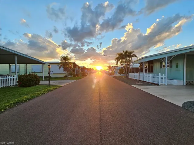 View of asphalt road featuring street lights and a residential view