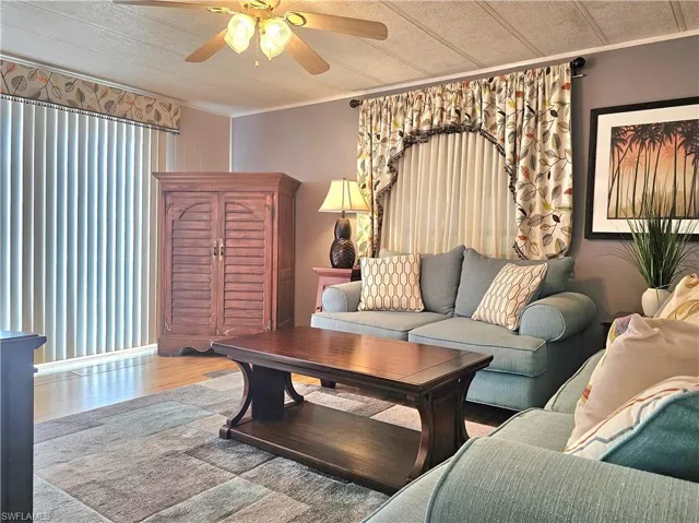 Living area featuring ornamental molding, wood finished floors, and a ceiling fan