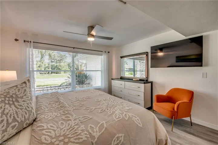 Bedroom featuring light wood-style flooring, baseboards, and a ceiling fan